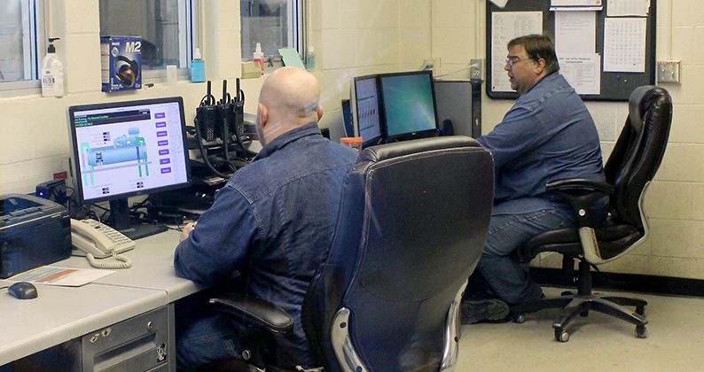 operators monitoring machinery status in operations room